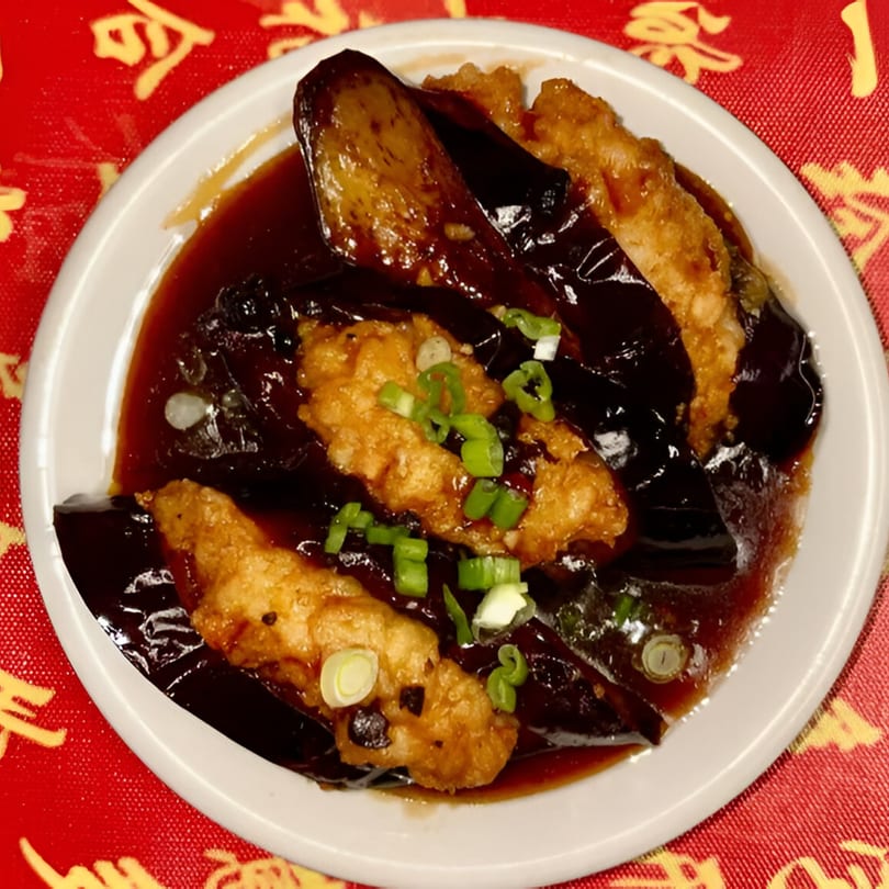Red Lantern's fried eggplant and chicken in a dark sauce, garnished with green onions.